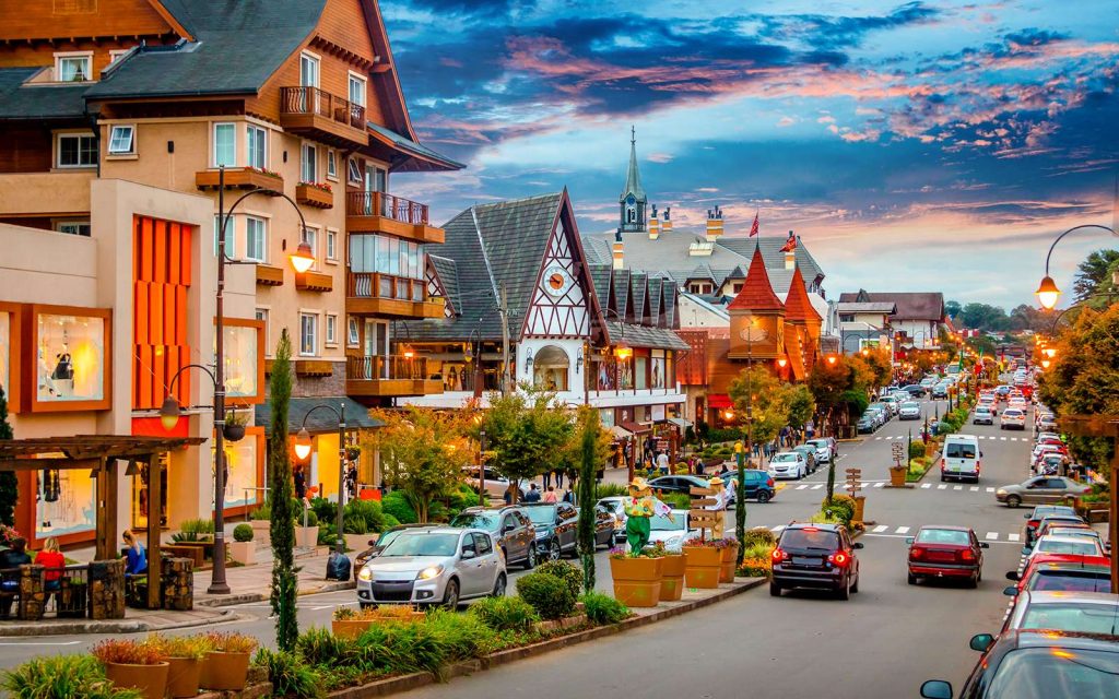 Rua tranquila de Gramado cercada por araucárias e arquitetura típica da Serra Gaúcha.