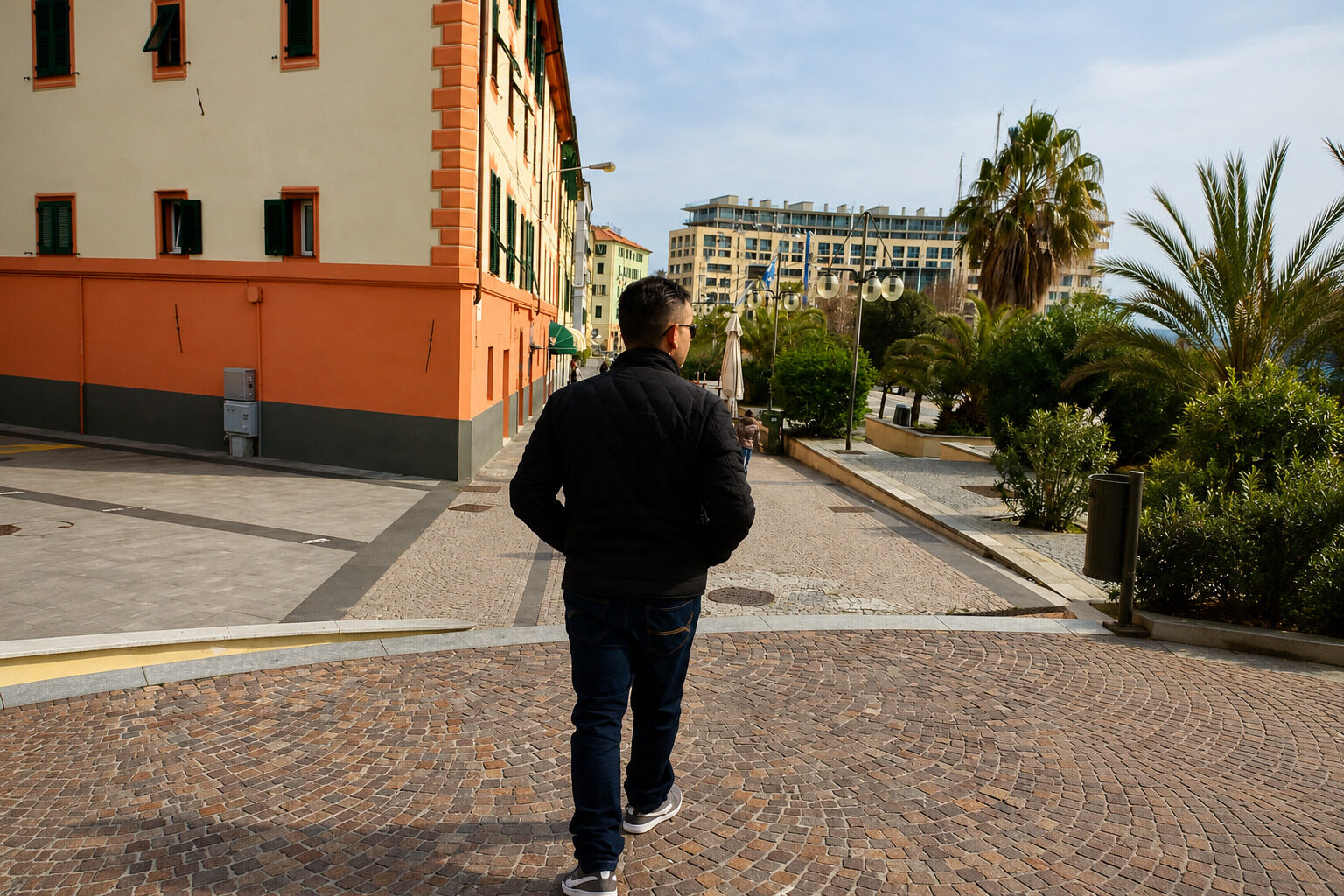 Viajante sentado observando uma pequena vila europeia ao pôr do sol durante uma viagem em ritmo lento.